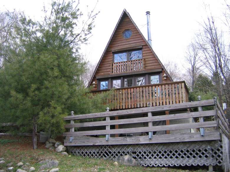 a large wooden chalet with a triangular roof and front deck