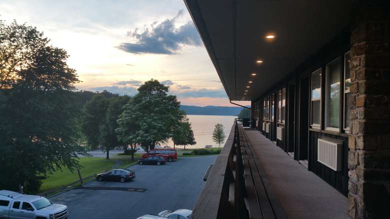 a view of the lake from the porch along hotel rooms