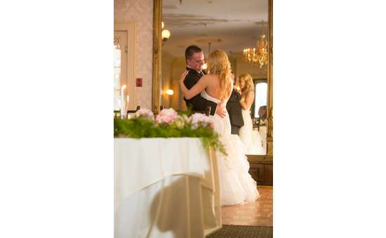 Newlywed couple dancing in front of mirror