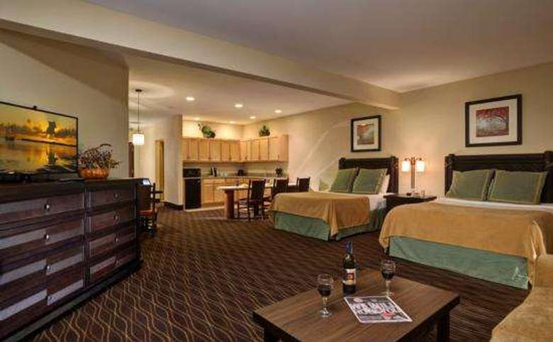 hotel suite with two double beds and a kitchenette area