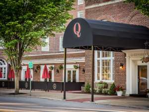 black awning with a red Q on it in front of an entrance to the queensbury hotel