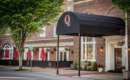 black awning with a red Q on it in front of an entrance to the queensbury hotel