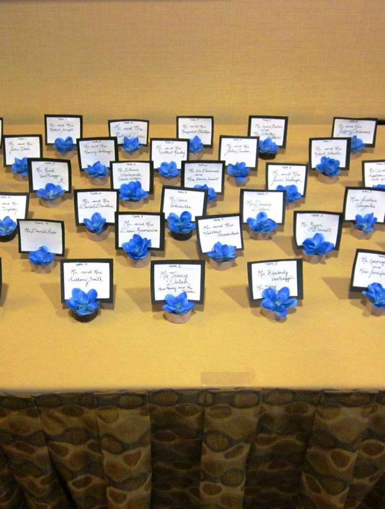 placards for guests arranged nicely on a table with a cornflower blue colored flower for each