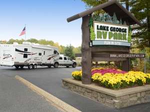 the sign for lake george rv park with a rv in the back