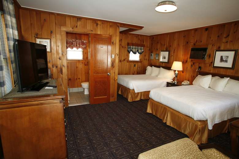 cabin 109 with two large beds and wood paneling