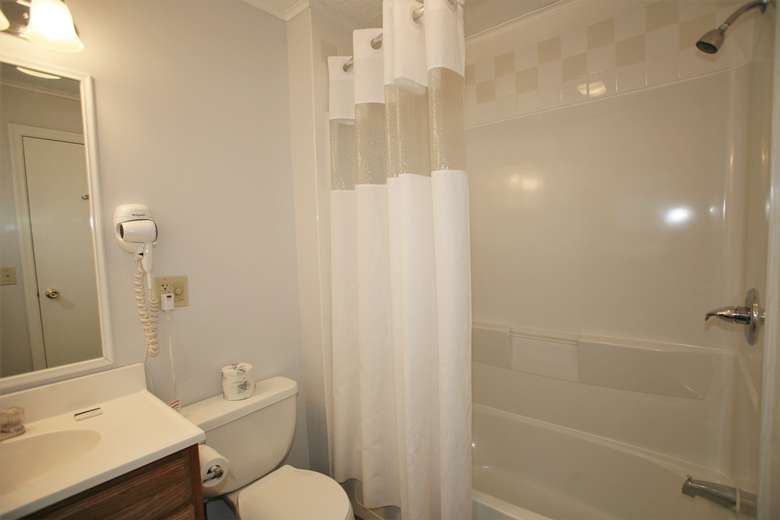 Clean bathroom with shower, tub and toilet
