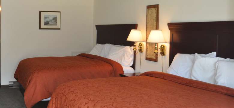 two beds with orangeish red bedspreads