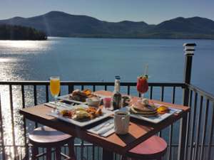 table with brunch food and drinks on a patio overlooking lake george