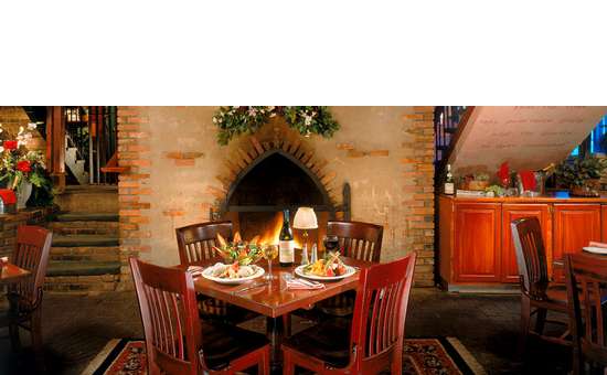 table for four at a restaurant set up in front of a fireplace