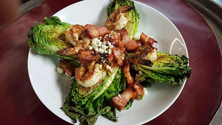 grilled shrimp and bacon on top of large lettuce leaves