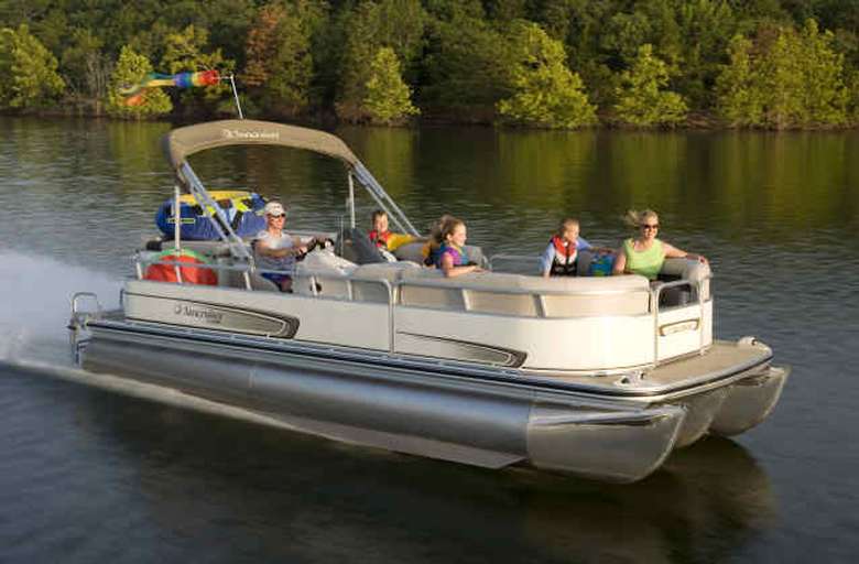 a large pontoon boat on the water that is filled with people
