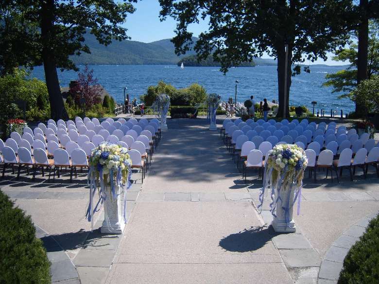 rows of white chairs set up for a wedding ceremony near the waterfront