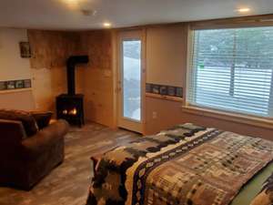 cabin with couch, bed, and fire in fireplace