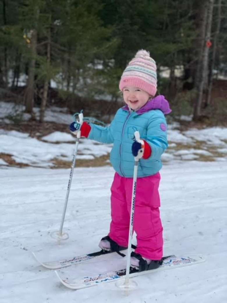 toddler skiing and smiling