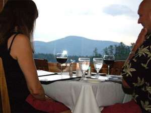 couple seated at table overlooking the lake, and the mountains in the distance