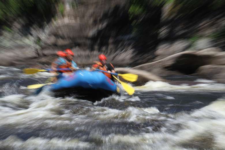 blurry image of people whitewater rafting