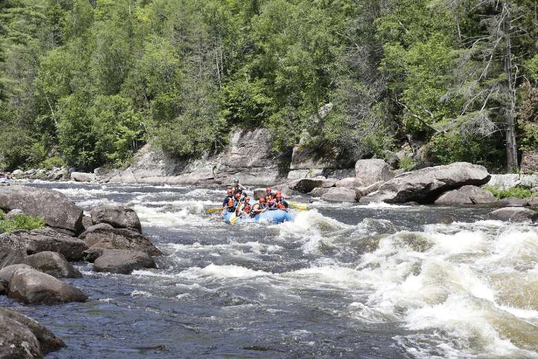 far view of people whitewater rafting