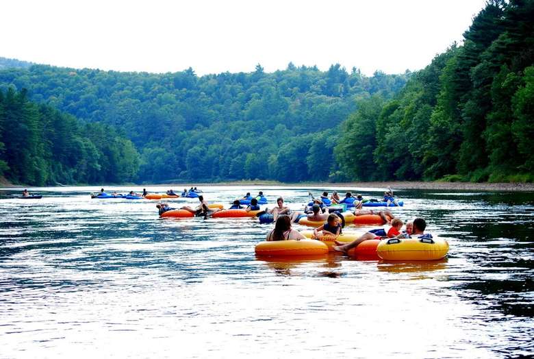 large group of people in yellow and blue tubes floating down the river