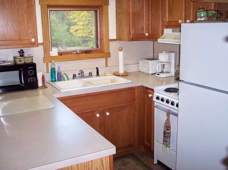 a small kitchen with wooden cabinets and a white refrigerator