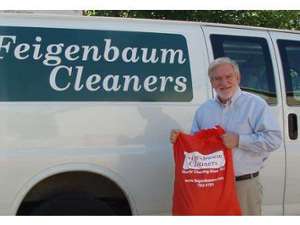 Man with dry cleaning bag in front of van