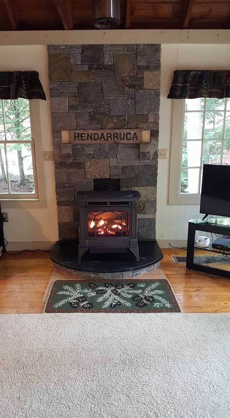 Iron fireplace against stone wall