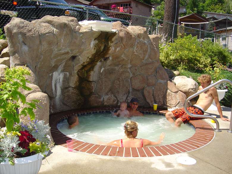people in an outdoor hot tub that's in the ground like an indoor pool