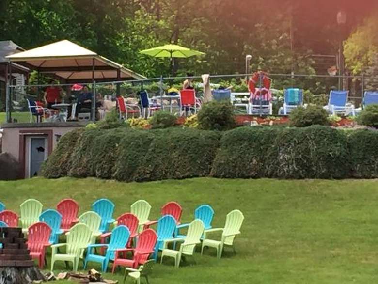 colorful Adirondack chairs, pool in the background