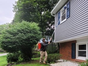 man doing pest control on a house