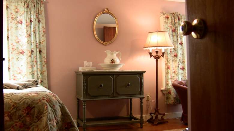 part of the bedroom with a  dresser, mirror, lamp