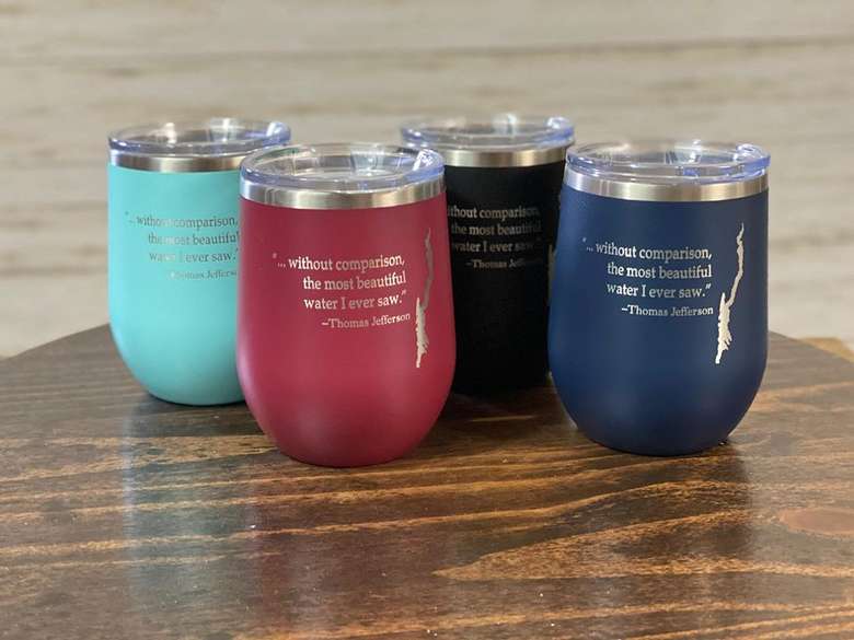 four tumbler mugs with quotes and an image of a lake