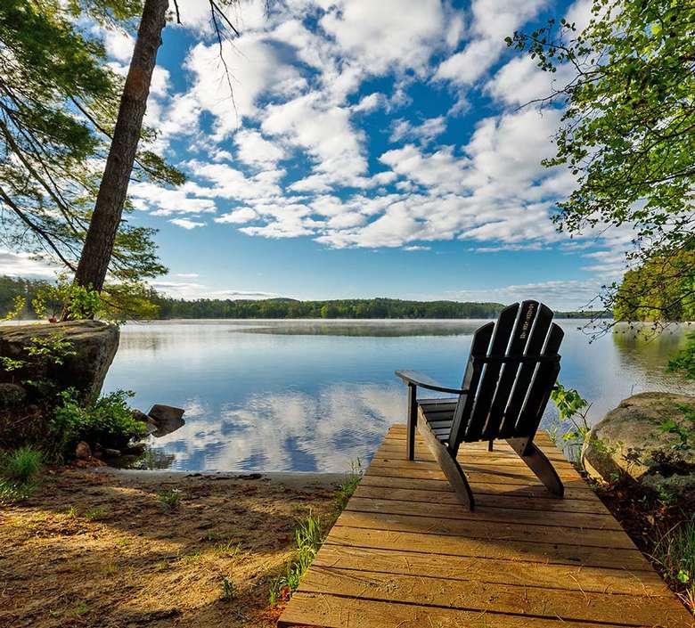 adirondack chair on a wooden dock by a lake