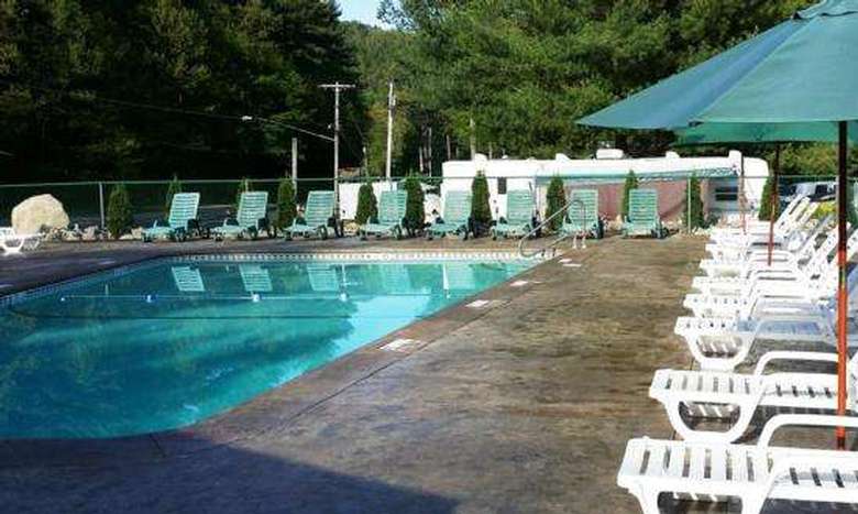 an outdoor pool surrounded by white chairs