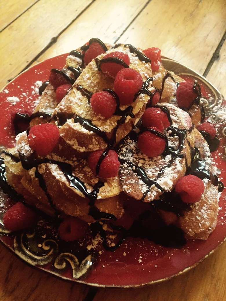 french toast with raspberries on a red plate
