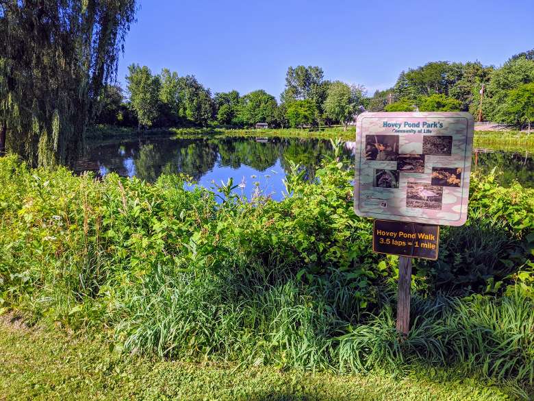 sign for hovey pond park with info on wildlife and that 3.5 laps around pond equals 1 mile
