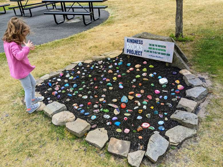 little girl looks at kindness rocks garden