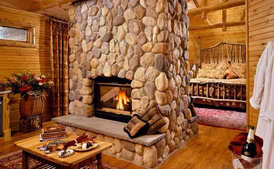 Guestroom "Birch" with a king-size bed and a huge floor-to-ceiling stone fireplace and jacuzzi