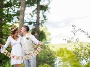 an couple just married holding a sign the says "we eloped"