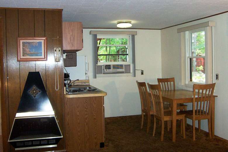 dining room area with table with four chairs, sink air conditioner in window