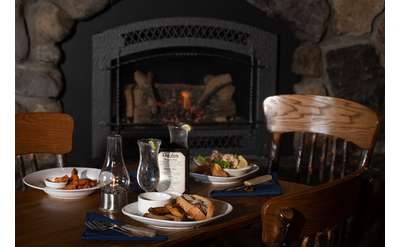 table of food next to a cozy fireplace