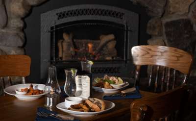 table of food next to a cozy fireplace