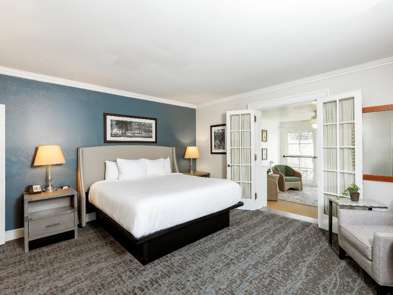 a hotel room with doors opening to living area