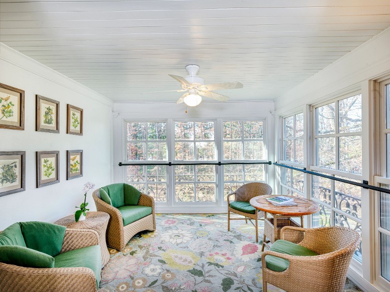 a sun room with chairs