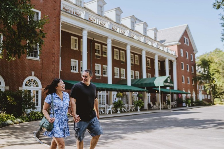 a man and woman walking near a hotel