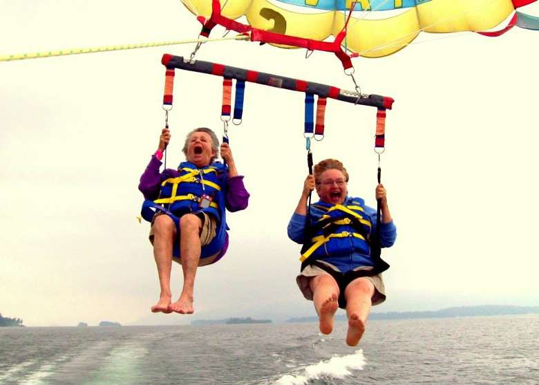 two older women parasailing and screaming