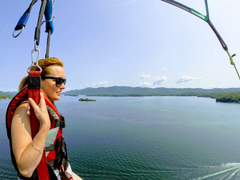 woman parasailing high above lake