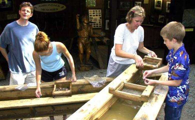 four people mining for gemstones in a trough