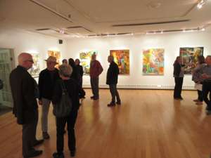 people in a gallery with paintings on the wall