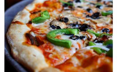 close up view of a pizza with peppers and mushrooms