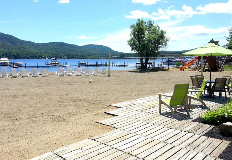 colorful chairs and a sandy beach overlooking lake george
