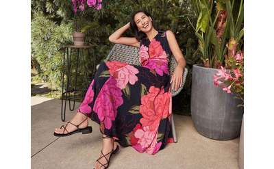 woman in a floral print dress lounging on a chair